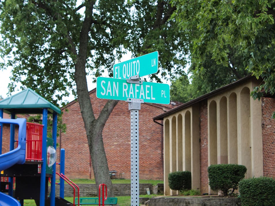 a street sign in front of a playground