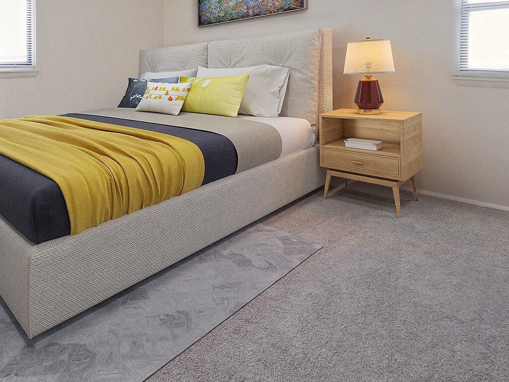 a bedroom with a bed and a nightstand with a lamp