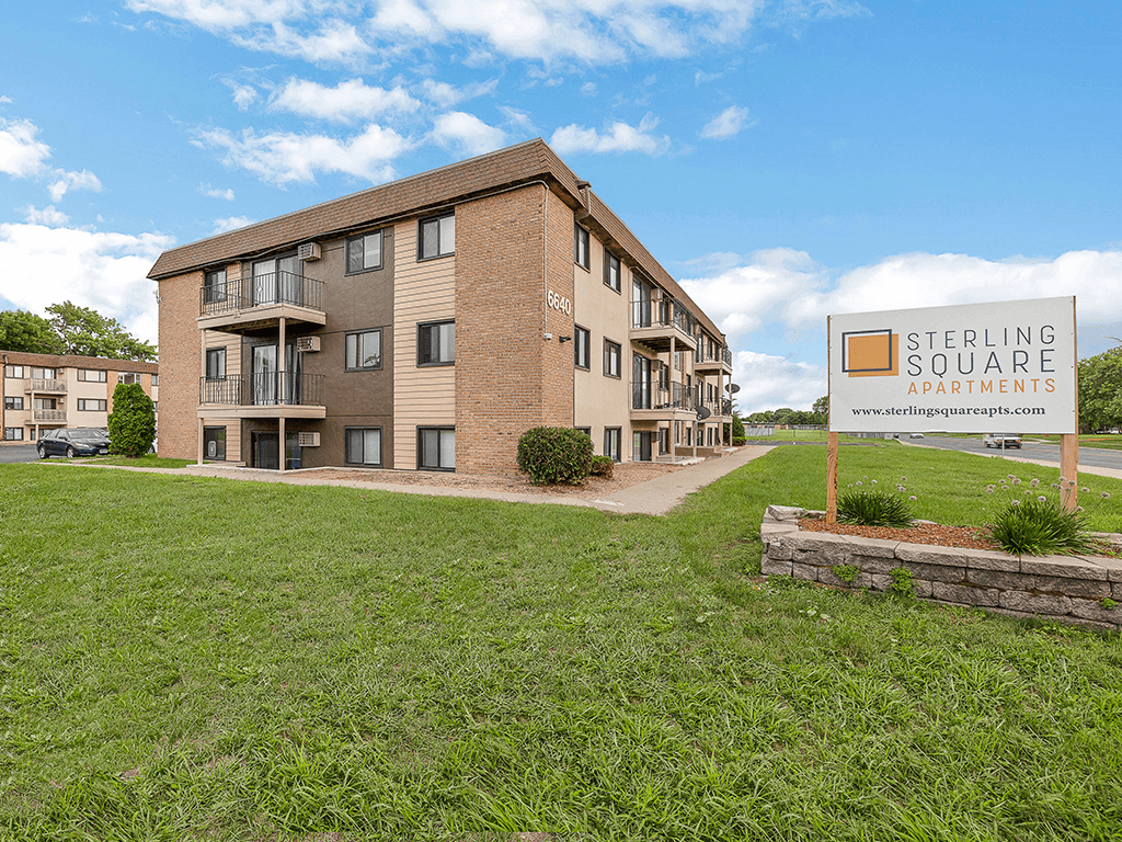 an apartment building with a leasing sign in front of it