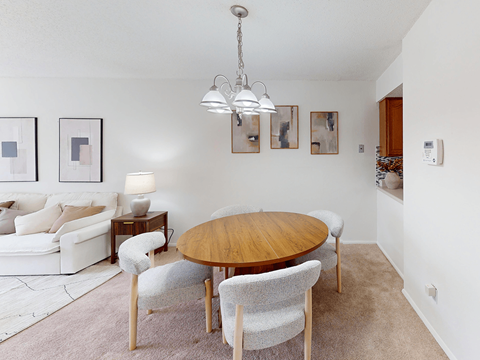 A modern dining room with a wooden table and chairs.