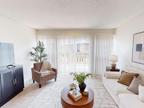 A living room with a brown armchair, a white sofa, and a wooden coffee table.