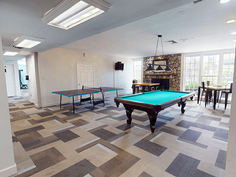 A room with a pool table and a fireplace.