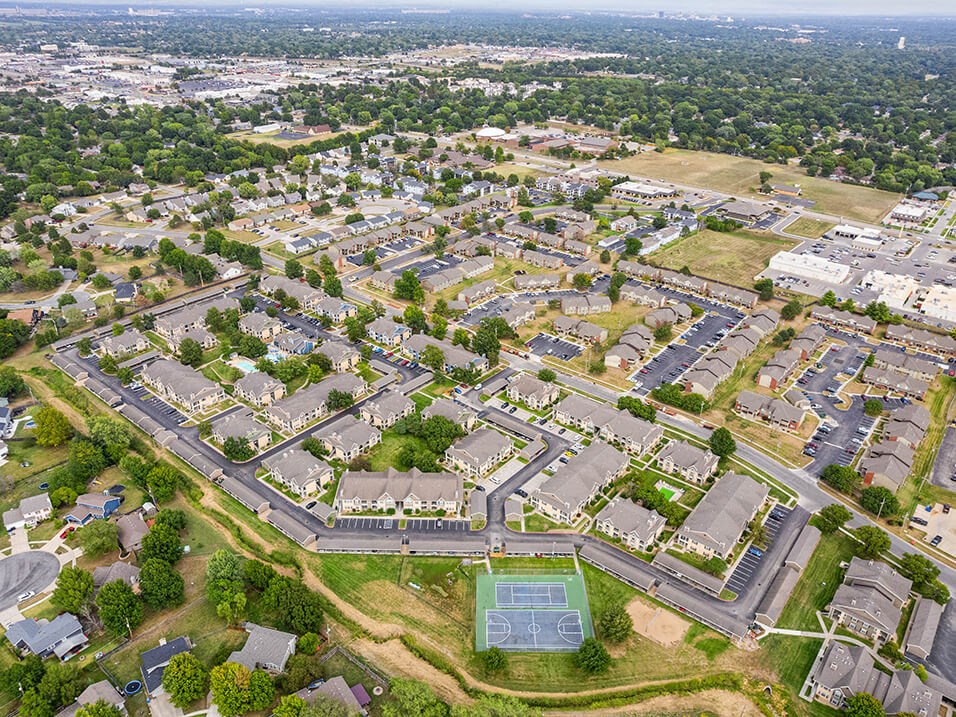 an aerial view of a city with houses and a tennis court