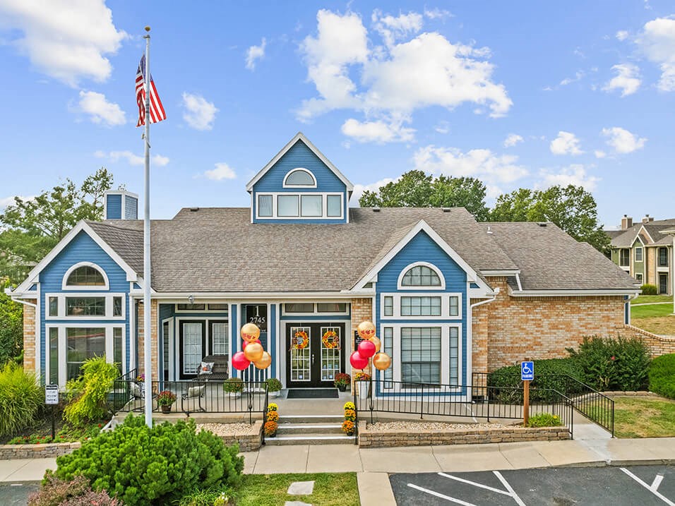 the front of a house with balloons and an flag