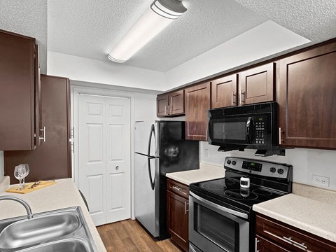 a kitchen with black appliances and wooden cabinets