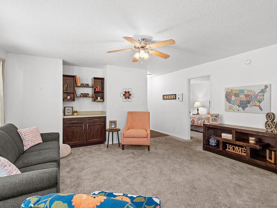 a living room with a couch and a ceiling fan