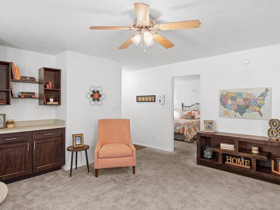 a living room with a ceiling fan    and a bedroom