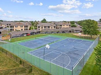 a tennis court with apartments in the background