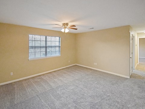 primary bedroom with a ceiling fan and a window with blinds