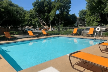 a swimming pool with orange lounge chairs around it