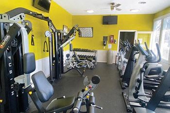 a gym with weights and other equipment in a yellow room
