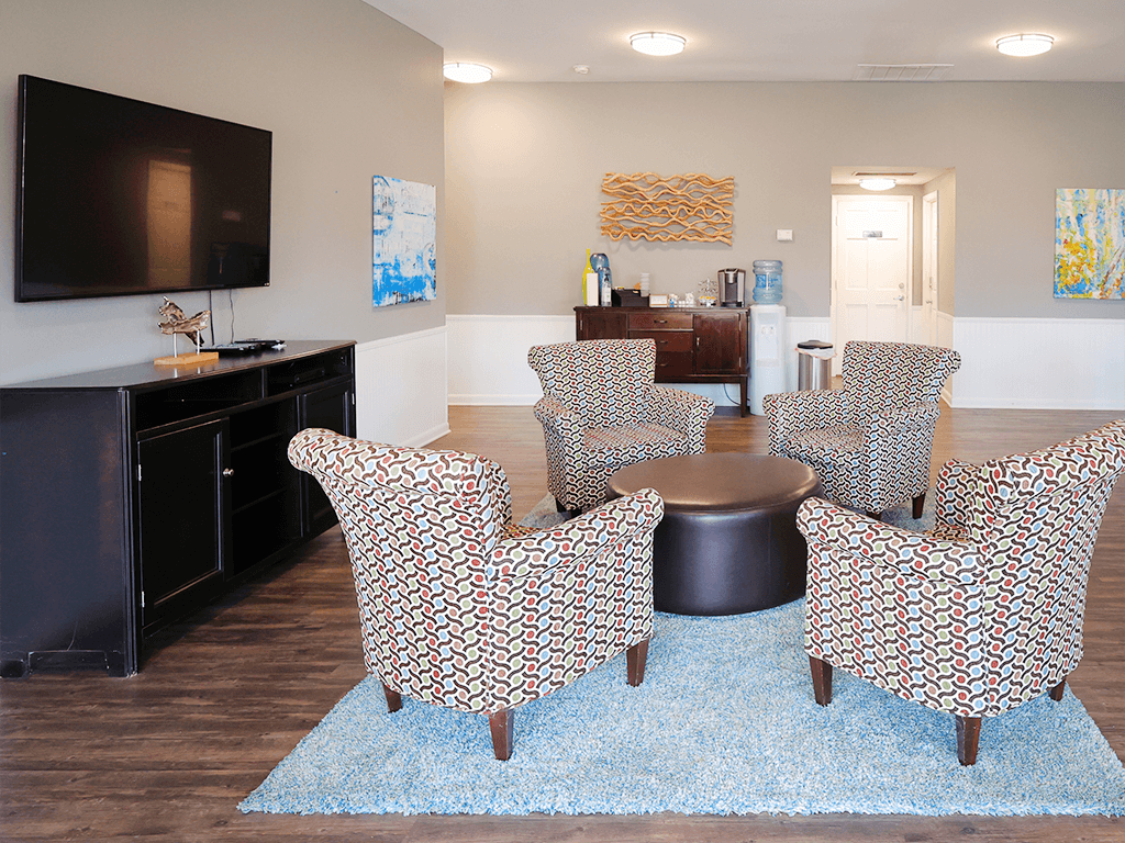 a living room with chairs and a table and a tv