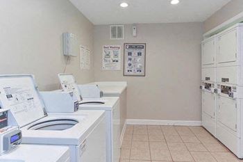 a laundry room with four washing machines