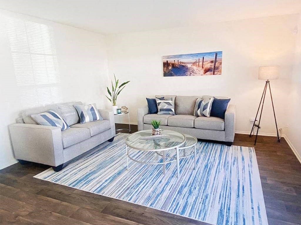 a living room with two couches and a glass table