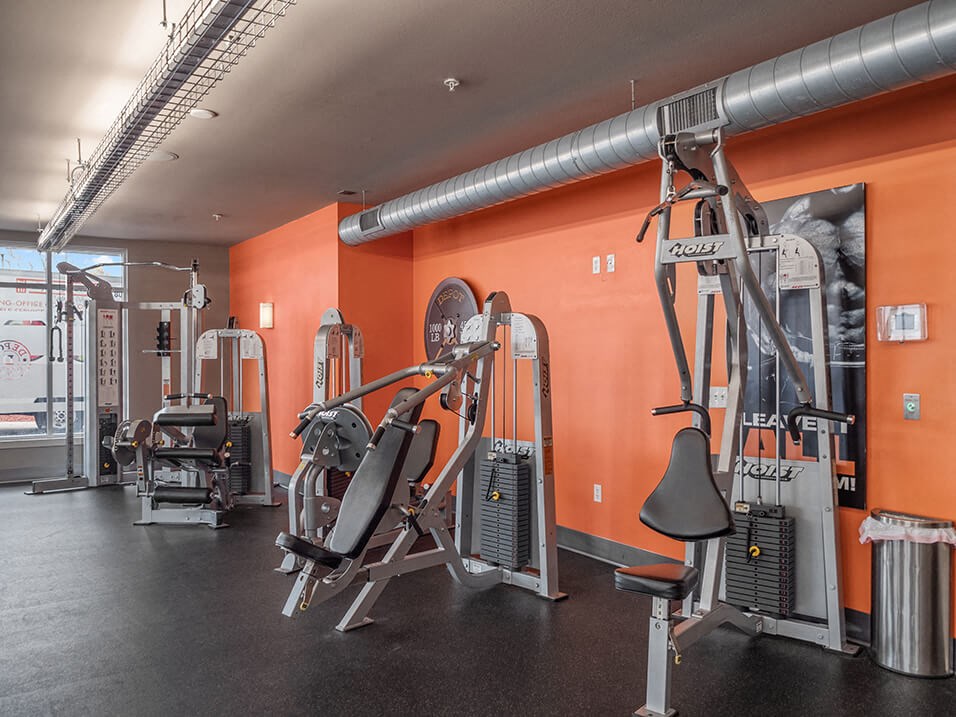 a gym with weights machines and a poster on the wall