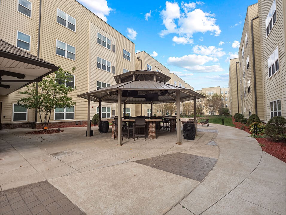 a patio with a table and chairs in front of a building