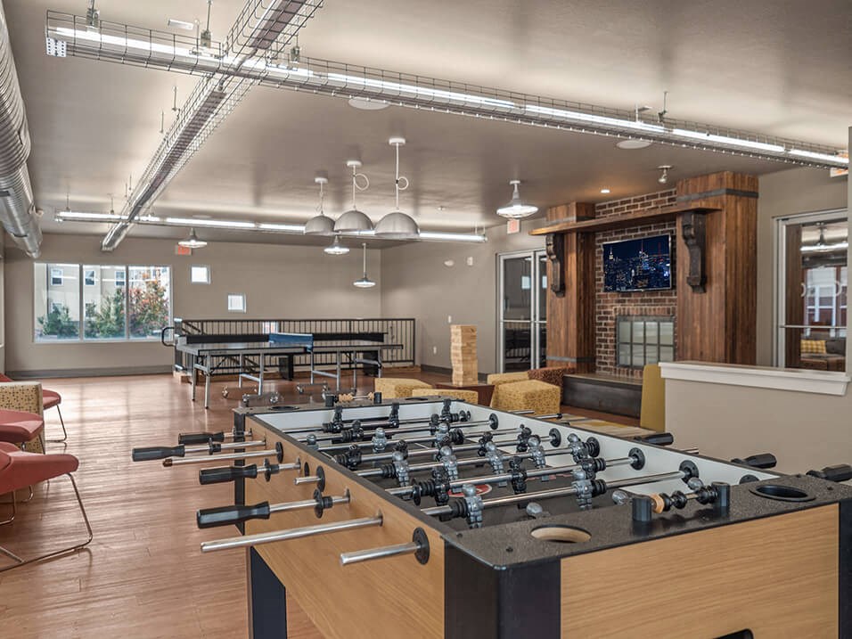 a game room with foosball and ping pong tables