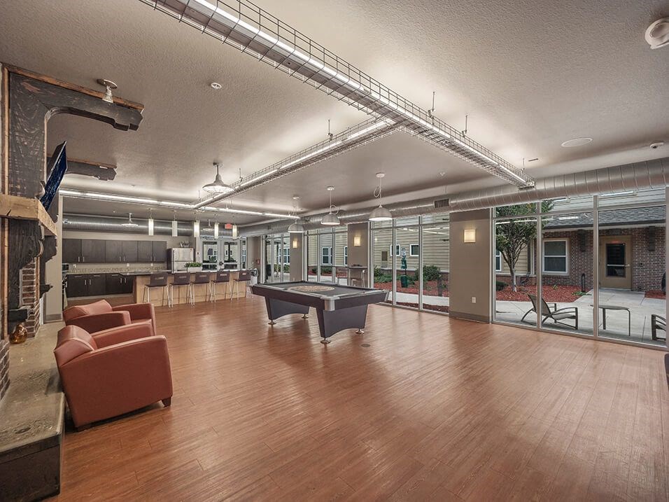 a large room with a pool table and chairs