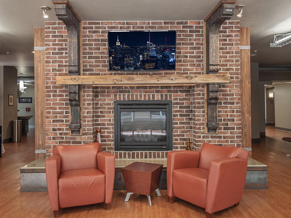 a rec room with a fireplace and chairs
