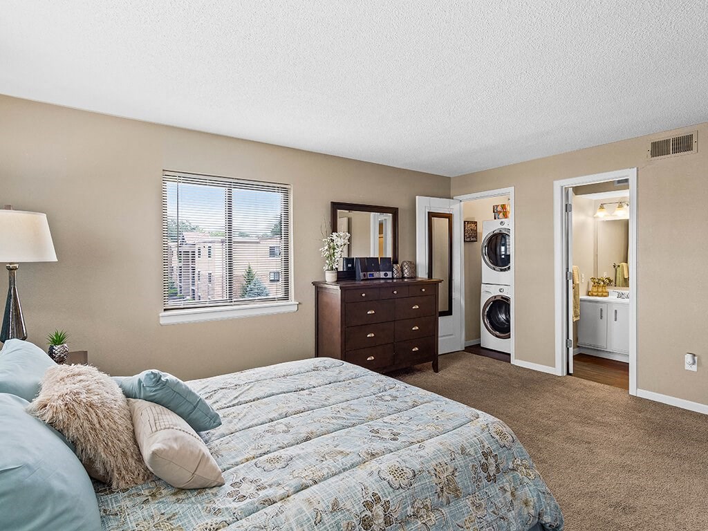 a bedroom with a bed and a washing machine