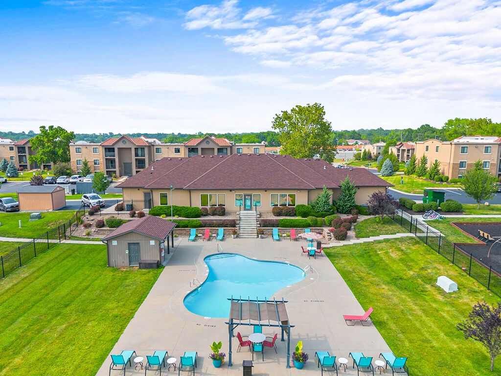 an aerial view of an outdoor swimming pool with umbrellas and tables and chairs