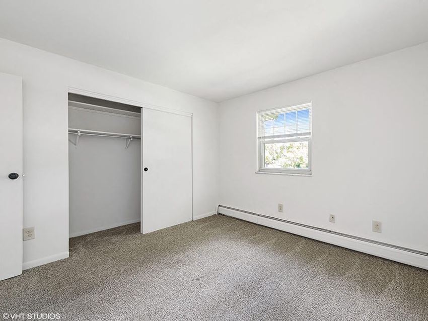 an empty room with a closet and a window