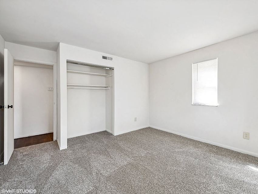 an empty room with a closet and a window