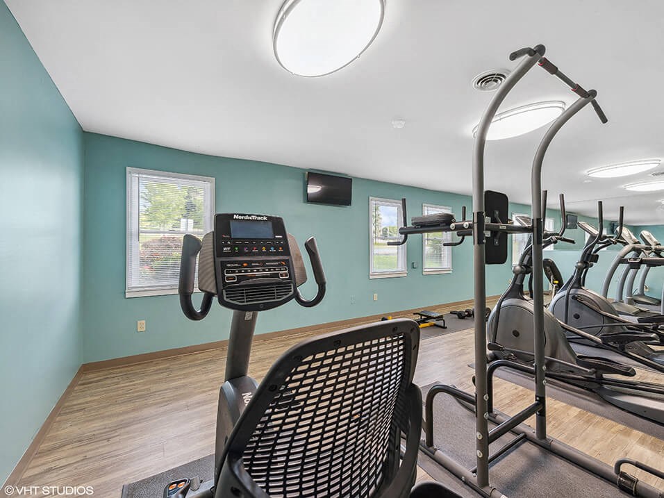 a gym with various machines and a light on the ceiling