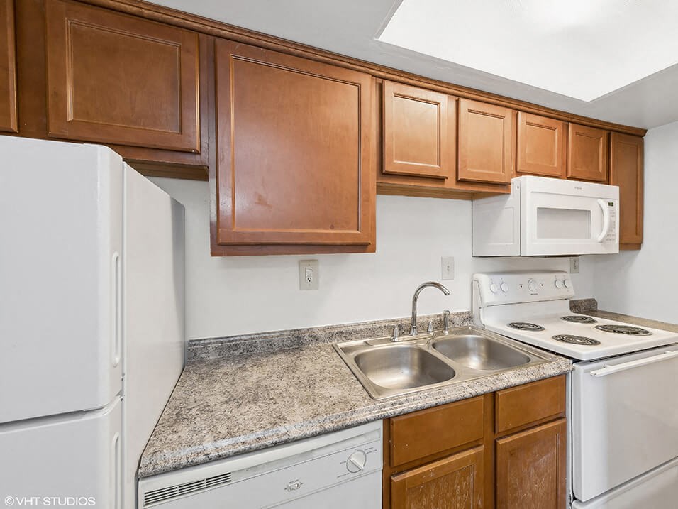 apartment kitchen with appliances and wooden cabinets