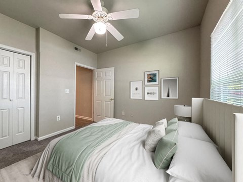 a bedroom with a large bed and a ceiling fan