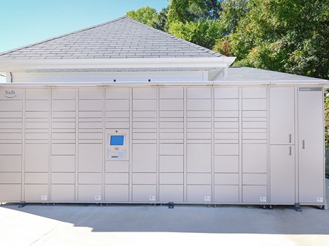 A large white building with a grey roof and a sign that says hub on the top left.
