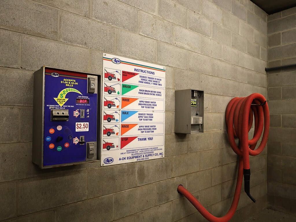 A parking garage with a sign that says "AC/DC COMPONENTS" and a red extension cord plugged into the wall.