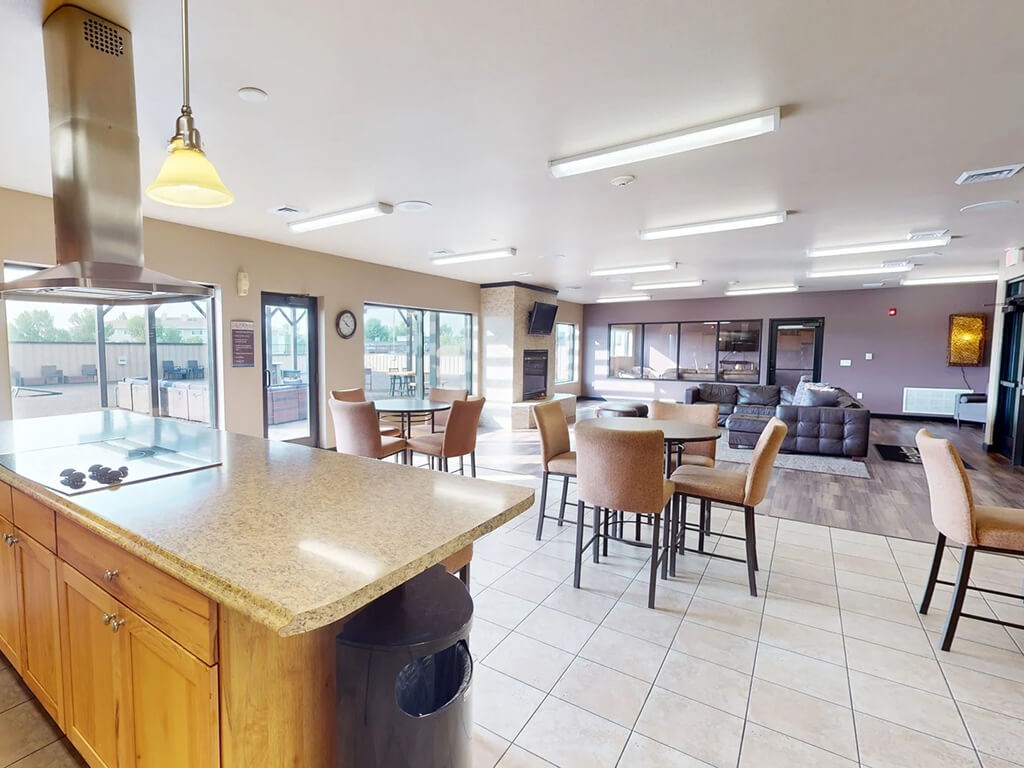 A kitchen with a counter and chairs.