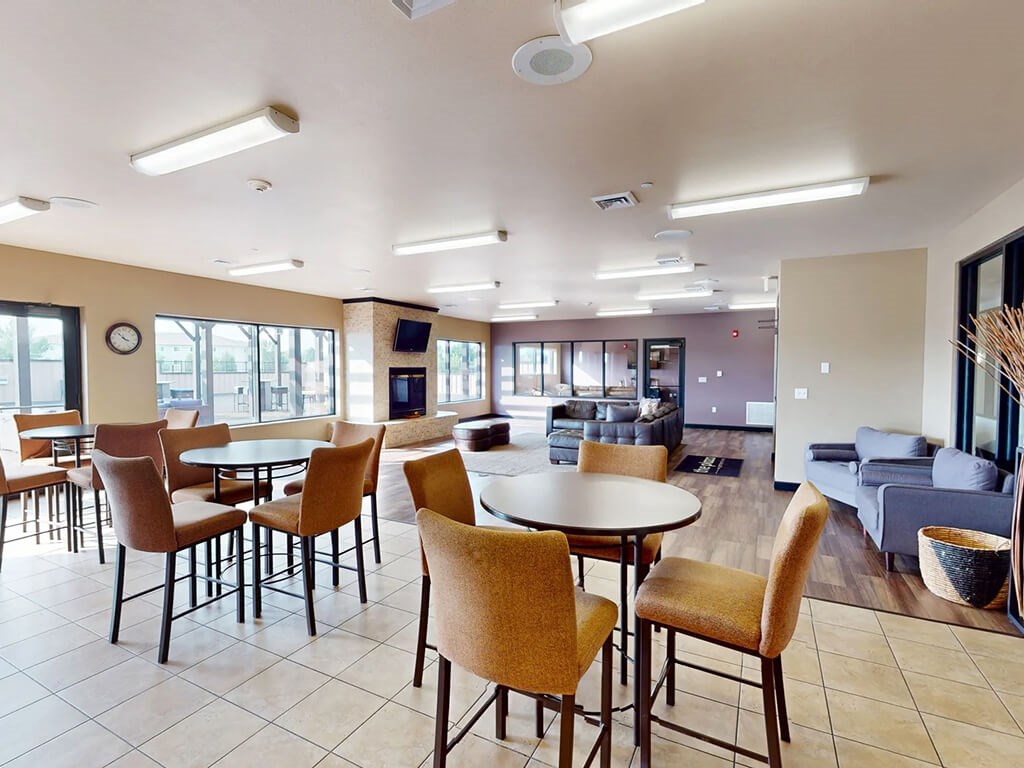 A large room with a table and chairs in the foreground.