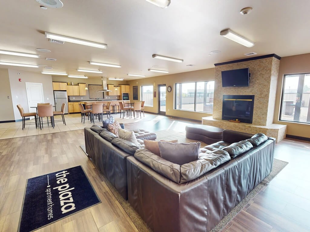 A living room with a couch and a television on the wall.