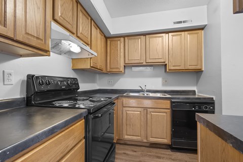 A kitchen with wooden cabinets and black appliances.