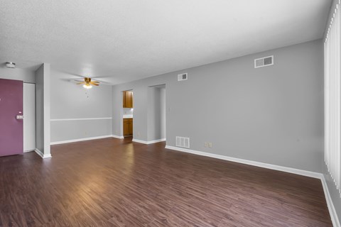 A room with wooden floors and a ceiling fan.