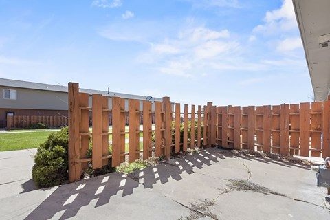 A wooden fence runs along the side of a building.