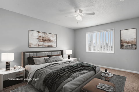 A bedroom with a large bed and two lamps.