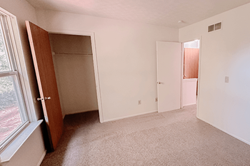 an empty bedroom with a large closet and a window