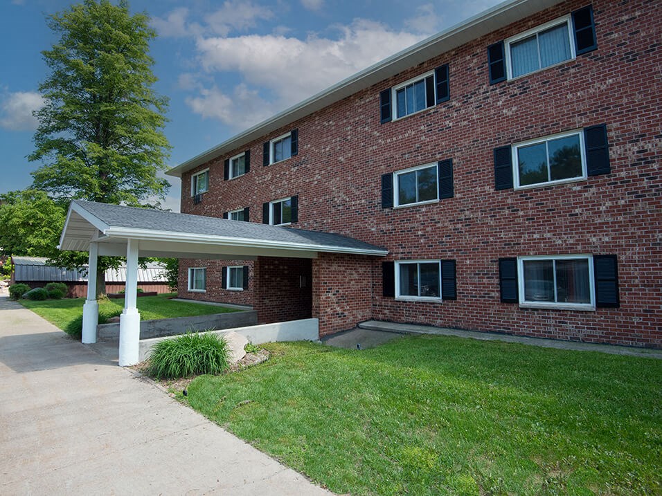a large brick apartment building with a covered walkway in front of it