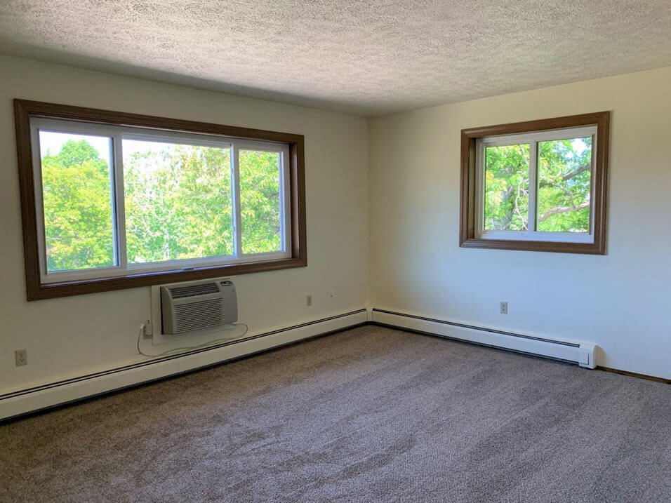 an empty room with two windows