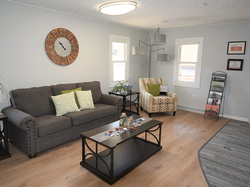 a living room with gray walls and a large clock on the wall