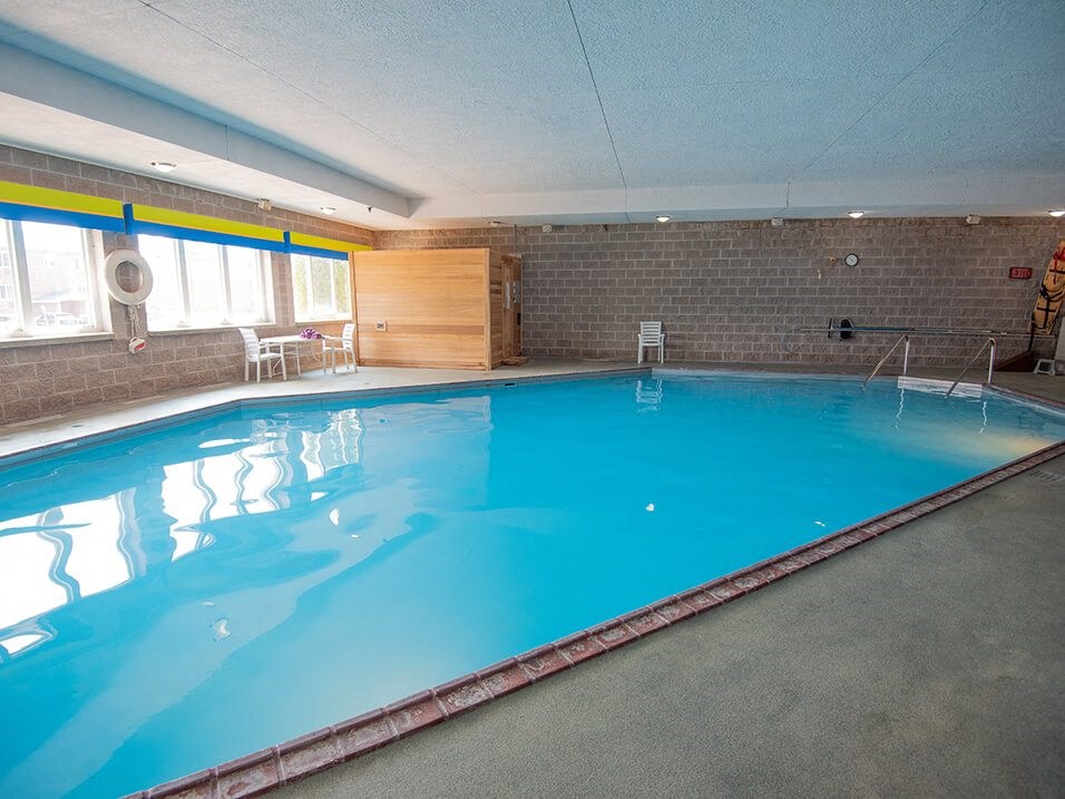 a large indoor swimming pool with brick walls and a blue ceiling