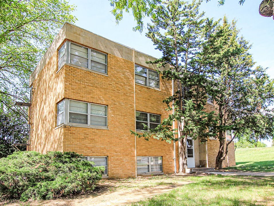 a brick building with trees in front of it