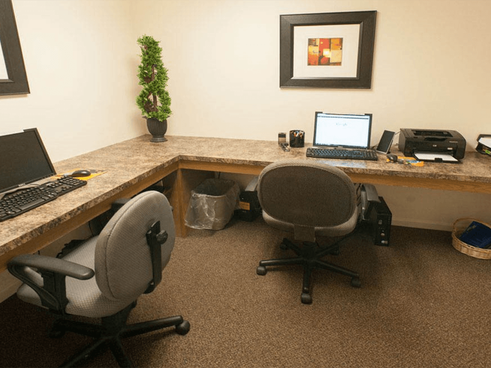 a desk with two chairs and a laptop computer