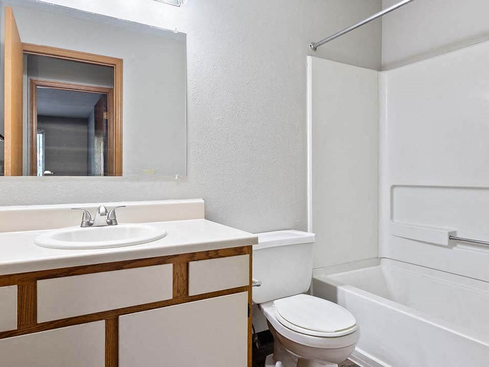 apartment bathroom with a sink, toilet and a tub