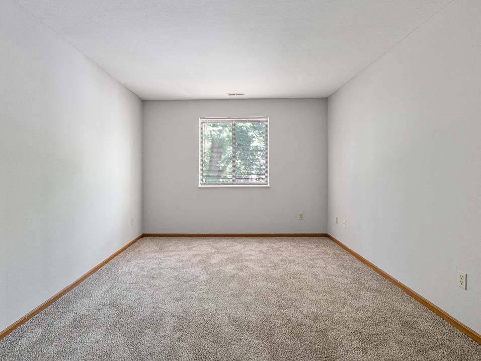 apartment bedroom with carpet and a big window