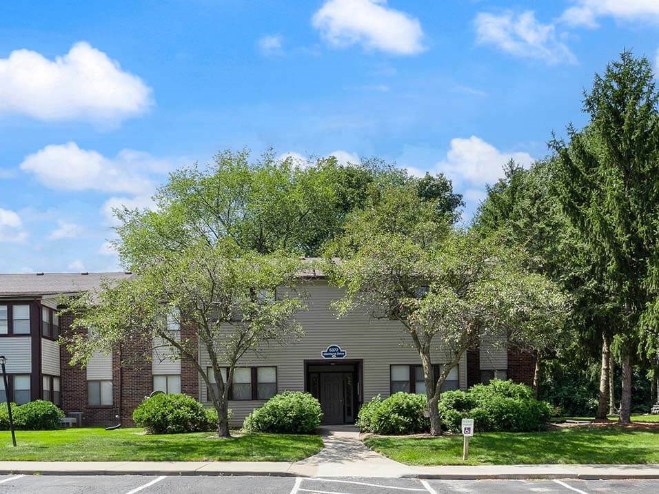 apartment building with shade trees and off street parking