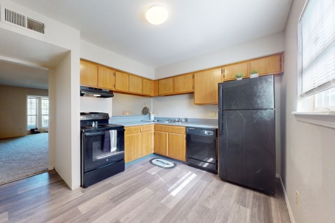 A kitchen with wooden cabinets and black appliances.